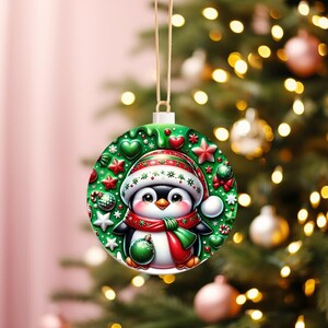 May include: A round Christmas ornament featuring a cartoon penguin wearing a red and green scarf and hat. The ornament has a green background with red stars, hearts, and other festive decorations. A gold string is attached for hanging.