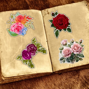 May include: Four floral stickers on an open book. The stickers feature roses in various colors: red, pink, and purple. The stickers have a white border and are set against a vintage-style paper background.