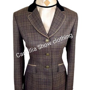 May include: A brown plaid equestrian show jacket with a black velvet collar and gold buttons. The jacket has a tailored fit with a cream-colored trim and the text "Camilla Show clothing".