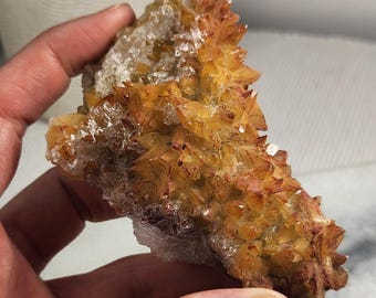 May include: A raw mineral specimen featuring a cluster of sharp, pointed crystals in shades of golden yellow and deep amber. The crystalline structure displays a translucent quality with visible internal fractures and a rough, jagged texture.