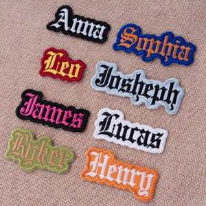 May include: Embroidered name patches in various colors and fonts, including "Anna," "Sophia," "Leo," "Josheph," "James," "Lucas," "Ryker," and "Henry." Each patch features a different color combination, such as black and white, red and yellow, and pink and black.