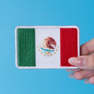 Pode incluir: Patch retangular bordado com a bandeira mexicana. O design apresenta listras verticais verdes, brancas e vermelhas, com o bras&atilde;o mexicano no centro. O patch tem uma borda branca e est&aacute; sobre um fundo azul.