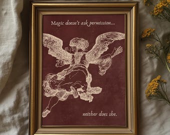 May include: Framed artwork featuring a sepia-toned illustration of an angel with outstretched wings against a burgundy background. The text reads "Magic doesn't ask permission... neither does she." The frame is gold.