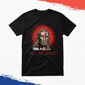 May include: A black short-sleeve t-shirt featuring a graphic print of a figure with long brown hair and a beard, with half of the face depicted as a metallic cyborg. Behind the figure is a red sunburst. The text I'LL BE BACK is printed in red.