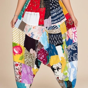 May include: Harem pants featuring a vibrant patchwork design with various fabric patterns including floral, geometric, and solid color blocks in red, yellow, blue, black, and white. The pants have an elastic waistband and gathered ankle cuffs.