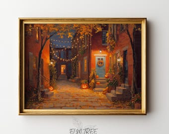 May include: A framed art print depicting a cobblestone street at dusk with brick buildings, glowing string lights, and orange pumpkins on the steps. The scene features a blue front door with a wreath, autumn foliage, and warm lighting throughout.
