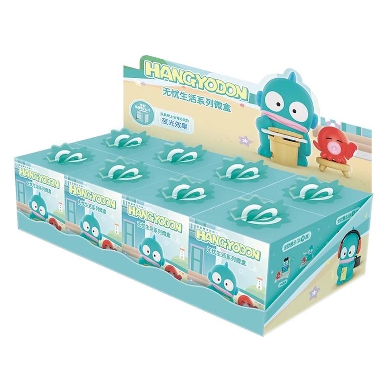 May include: A display box featuring Hangyodon character merchandise. The box is primarily teal and white, with illustrations of the character and Japanese text. The box contains several small, individually packaged items with a teal and white design.