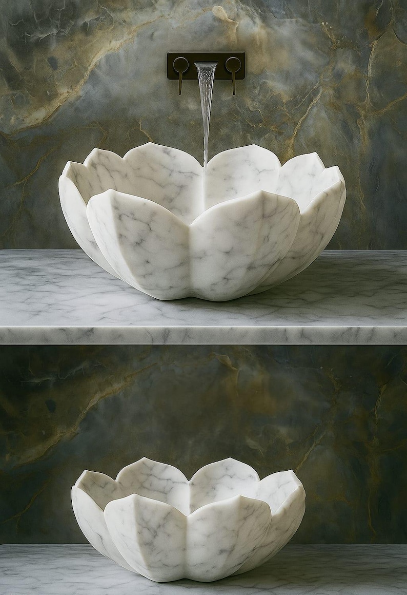 May include: A white marble lotus flower-shaped sink with water flowing from a dark metal tap. The sink is set on a marble countertop, with a matching sink below. The background features a marbled wall.