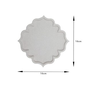 May include: A light gray, decorative tray with a unique, scalloped quatrefoil shape. The tray measures 16cm by 16cm, or approximately 6.3 inches by 6.3 inches. The tray has a textured surface and is suitable for home decor.