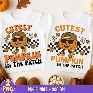 May include: Two white t-shirts with a cartoon pumpkin wearing sunglasses and a cap. The shirts have the text "Cutest Pumpkin in the Patch" in orange and black. The design includes peace signs and fall leaves.