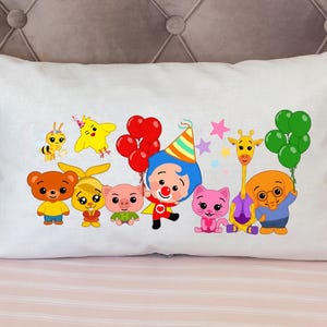 May include: White rectangular pillow with a colorful cartoon design featuring various animals and characters. The design includes a bee, a yellow bird, a bear, a pig, a clown, a cat, a giraffe, and an elephant, all holding balloons. The pillow is on a pink striped surface.