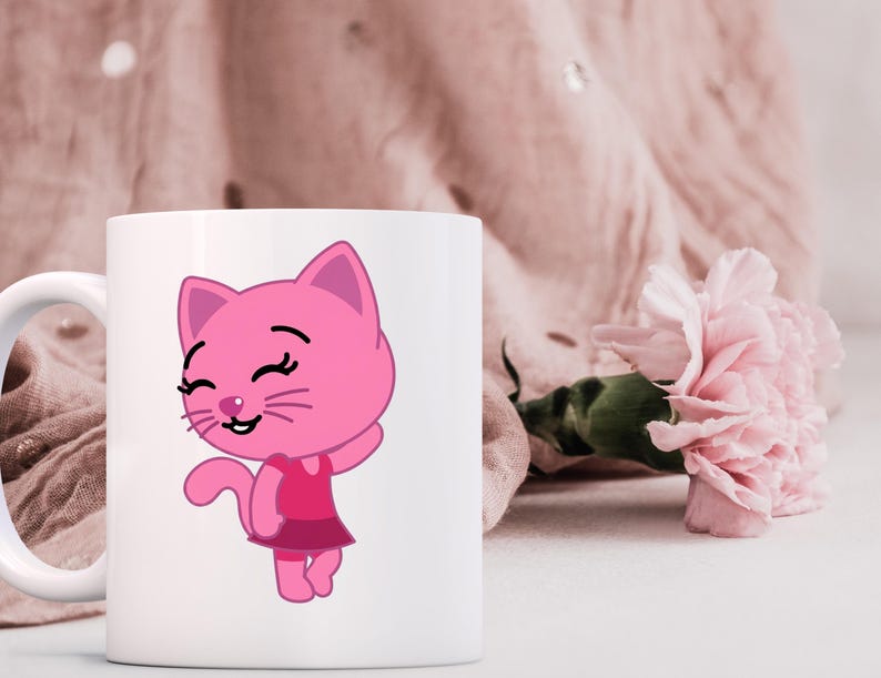 May include: White ceramic mug featuring a pink cartoon cat with a dress. The cat has a smiling face and is waving. A pink flower and a pink fabric are in the background.