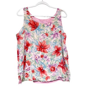 May include: A sleeveless, pink and white floral print top with a pink lining. The top has a scoop neck and a relaxed fit.