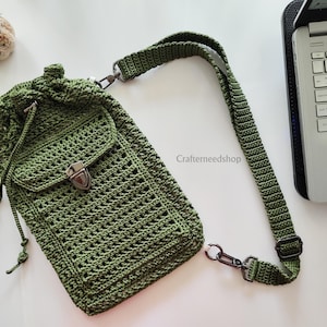 May include: Olive green crochet crossbody bag with a drawstring closure and a front pocket secured by a metal clasp. The bag features a long, adjustable strap with metal hardware. The bag is handmade and has a textured, open weave design.