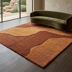 Terracotta and mustard abstract wool rug styled in a living room, adding warm earthy color and organic movement to the floor.