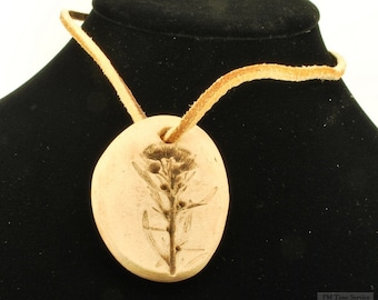 Handmade ceramic flower pendant with a recessed design of a bloom, matching suede leather necklace