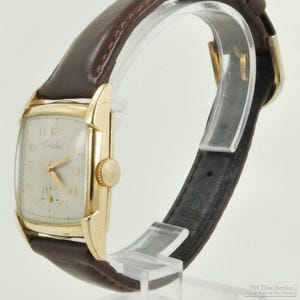 Cortebert vintage wrist watch, 17 jewels, elegant yellow gold (filled) rectangular smooth polish case with a tapered narrow bezel
