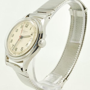 May include: A vintage silver wristwatch with a cream face. The watch has black numerals, a red second hand, and a flexible metal strap. The watch face reads "Fortis Special".