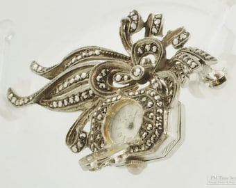 Vintage damesbrochehorloge van Bucherer, 17 juwelen, zilverkleurige art nouveau-speld van Fondacier met marcasietaccenten.