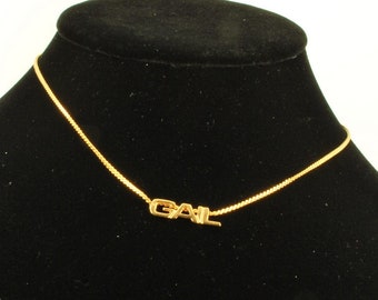 Gold-toned base metal 15" serpentine-link choker-style necklace with an affixed "Gail" pendant