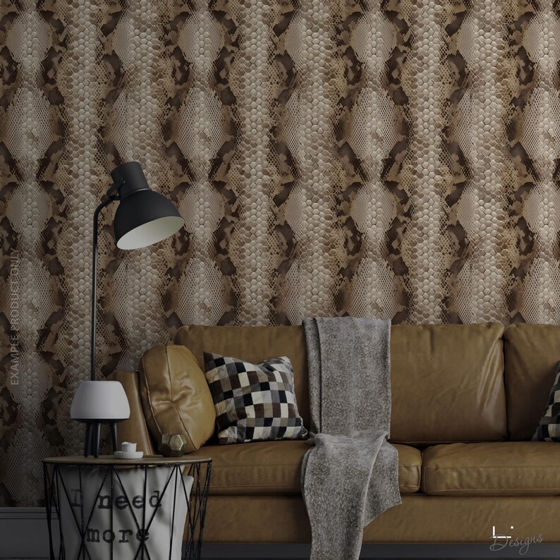 Puede incluir: Papel pintado con un patr&oacute;n repetitivo de piel de serpiente en tonos marr&oacute;n y beige. El dise&ntilde;o muestra texturas de escamas realistas en bandas verticales. El papel pintado se muestra detr&aacute;s de un sof&aacute; de cuero marr&oacute;n y una l&aacute;mpara negra.
