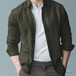 May include: A long-sleeved button-down shirt featuring a dark olive green and black snakeskin-like scale pattern. The shirt is worn unbuttoned over a plain white polo shirt, paired with dark grey trousers. The text EXAMPLE PRODUCT ONLY is visible.