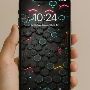 May include: A black smartphone showing a digital wallpaper with a hexagonal design. The screen displays the time 10:24 and the date Monday, November 17. The design incorporates neon pink, blue, and yellow accents.