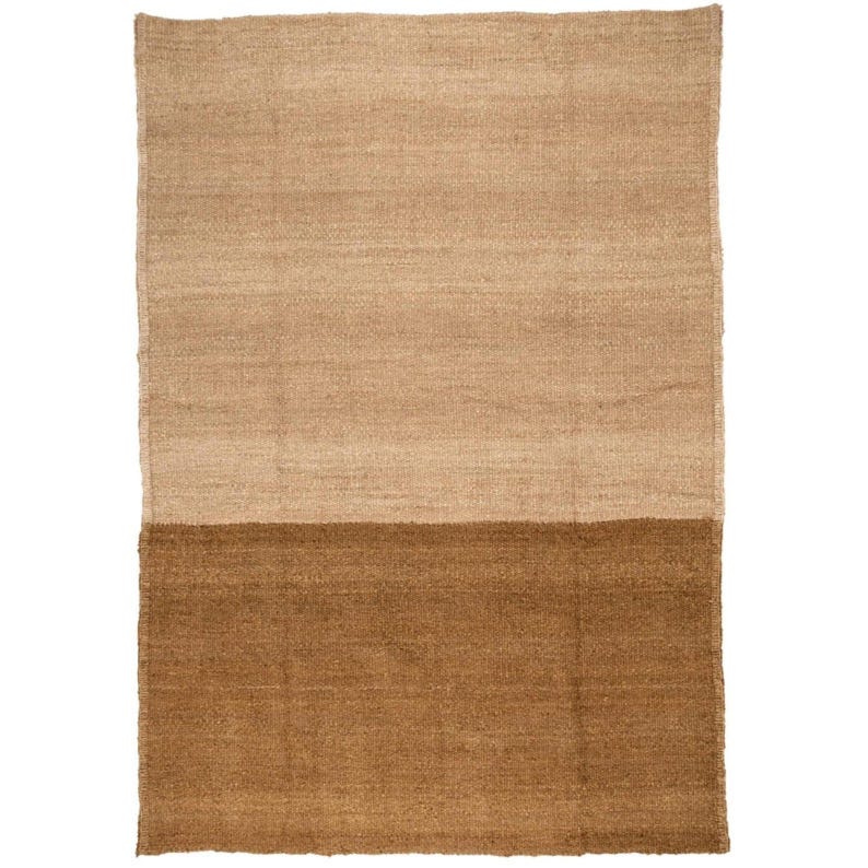 May include: A rectangular rug with a two-tone design. The top half is a light tan color, and the bottom half is a darker brown. The rug appears to be made of a woven material, possibly jute or a similar natural fiber.