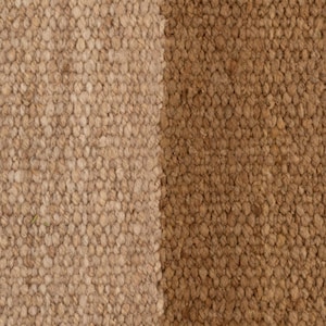 May include: Close-up of a textured rug with two vertical sections. One section is a light tan color, and the other is a medium brown. The rug has a woven appearance, with visible fibers and a nubby texture.