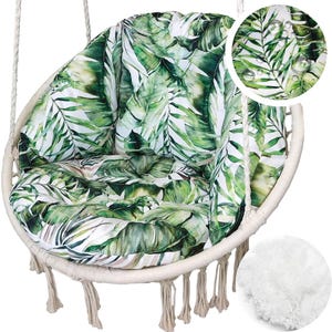Peut inclure: Un fauteuil suspendu avec un cadre blanc et des franges en macramé. Le fauteuil est doté d'un grand coussin rond avec un motif de feuilles tropicales vertes et blanches. Le fauteuil est suspendu par de grosses cordes blanches.