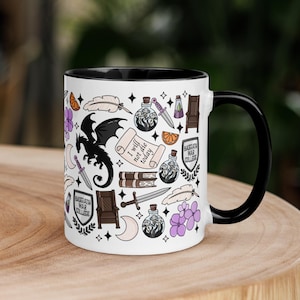 Op de afbeelding: Witte keramische mok met een zwarte binnenkant en handvat, versierd met fantasie-thema illustraties. Het ontwerp bevat een zwarte draak, drankflessen, zwaarden en de tekst "I will not die today".