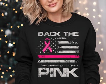 May include: Black sweatshirt with the words "BACK THE PINK" above a pink ribbon and a pink stripe, with a distressed American flag design. The word "PINK" is printed below the flag.