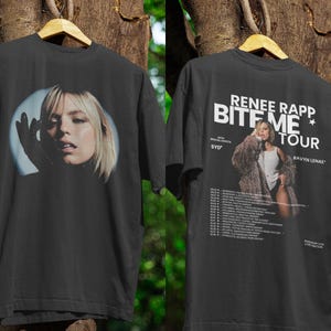 May include: Black t-shirt featuring a portrait of a blonde woman on the front. The back of the shirt displays the text "RENEE RAPP BITE ME TOUR" with a photo of the artist and tour dates.
