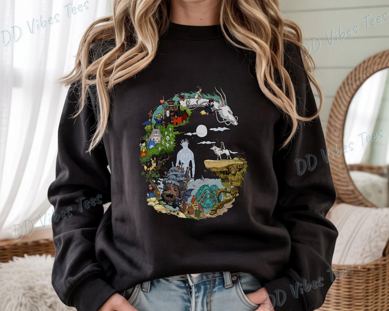 Puede incluir: Sudadera negra con un dise&ntilde;o gr&aacute;fico colorido que representa escenas y personajes de una pel&iacute;cula de animaci&oacute;n. El dise&ntilde;o incluye un drag&oacute;n blanco, una luna llena y varias figuras. El texto "DD Vibes Tees" est&aacute; impreso en la manga.