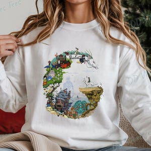 Puede incluir: Sudadera blanca de manga larga con un dise&ntilde;o gr&aacute;fico colorido. El dise&ntilde;o incluye ilustraciones de personajes y escenas de una pel&iacute;cula de animaci&oacute;n. El texto "DD Vibes Tees" est&aacute; impreso en la parte superior izquierda e inferior derecha de la sudadera.