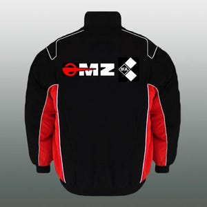 Può includere: Giacca nera con pannelli laterali rossi e dettagli bianchi. La giacca presenta la scritta "MZ" in rosso e bianco, insieme a un piccolo logo in bianco e nero. Ha un collo alto e un design sportivo.