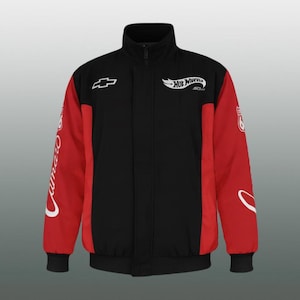 Puede incluir: Chaqueta negra y roja con cuello alzado y cremallera completa. La chaqueta presenta el logotipo de Chevrolet y la marca Hot Wheels. Las mangas son rojas con texto y gráficos blancos. La chaqueta tiene dobladillo y puños acanalados.