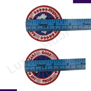 May include: Two round embroidered patches with red, white, and blue details. Each patch is approximately 2 inches (5 cm) in diameter. One patch reads "NA PROGRA" and the other reads "CAN GOOS ARC PROGI".