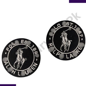 Può includere: Due toppe circolari nere con testo bianco e un logo di giocatore di polo. Le toppe hanno un bordo bianco e sono circondate da piccoli abbellimenti circolari grigi. Il testo include "POLO", "1986", "AL HLUEN", "LO ST. 187" e "LP LA RE".