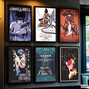 May include: Six framed posters showcasing artwork from the anime series Ghost in the Shell. The posters feature diverse characters and scenes, with a blend of vivid colours and stylized illustrations. The text "Ghost in the Shell" is visible on several posters.