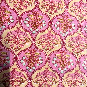 May include: A fabric featuring a repeating pattern of pink, scalloped, oval-shaped frames containing stylised floral motifs in shades of pink, light green, and yellow, set against a light beige background with thin, dark red, interconnected lines.