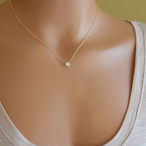 Puede incluir: Un delicado collar de cadena de oro con un peque&ntilde;o colgante en forma de estrella.