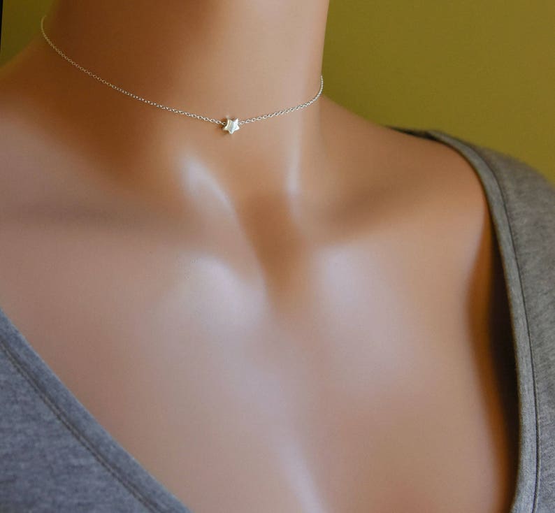 Puede incluir: Un delicado collar de cadena de plata con un peque&ntilde;o colgante de estrella.