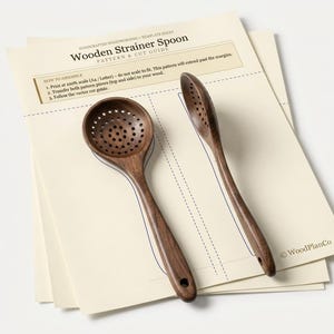May include: A dark brown wooden strainer spoon with a perforated bowl and a handle featuring a small hole, resting on a cream-colored paper template sheet titled Wooden Strainer Spoon Pattern & Cut Guide with assembly instructions.