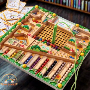 May include: Wooden maze game with colorful beads and a green handle. The game features a variety of paths, obstacles, and a bead-sorting section. The border is decorated with painted flowers and mushrooms. The logo "Tiny Trails" is in the bottom left corner.