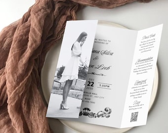 May include: A tri-fold wedding invitation with a black and white photo of a woman in a white dress. The invitation includes the names "Ana Silva & Jon Loeb", date, time, and RSVP information. The invitation is on a white plate with a brown fabric in the background.