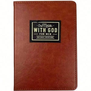 May include: A brown leather-bound book with the text "One Minute With God - For Men - 365 Daily Devotions" in a black and white rectangular patch. The book has a stitched border.