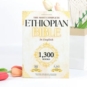 May include: A hardcover book titled "THE MOST COMPLETE ETHIOPIAN BIBLE" in English. The cover is cream-colored with gold lettering and decorative elements. It features the text "1,300 BOOKS" and mentions the inclusion of the Apocrypha.