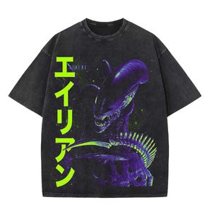 以下が含まれることがあります： 紫と緑のエイリアンのグラフィックが特徴の濃い灰色のTシャツ。 日本語の「エイリアン」の文字がシャツの左側に縦にプリントされています。 ヴィンテージ感のあるウォッシュ加工が施されています。