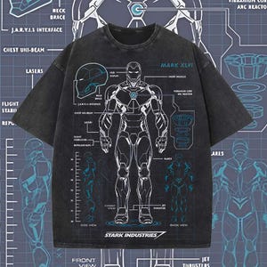 K&ouml;nnte beinhalten: Dunkelgraues T-Shirt mit einem schematischen Design der Iron Man Mark XLVI-R&uuml;stung. Das Design umfasst technische Diagramme, Beschriftungen und das Stark Industries-Logo. Das T-Shirt hat einen Rundhalsausschnitt und kurze &Auml;rmel.